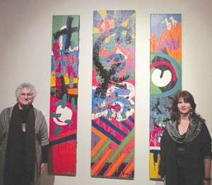 Armenian Art Exhibit curators Joyce Kierejczyk, left, and Carol Tikijian in front of art work by Varaz Samuelian. The works of eleven Armenian artists are featured in the exhibit.
